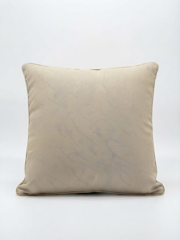 Coussin beige avec des motifs bleus
