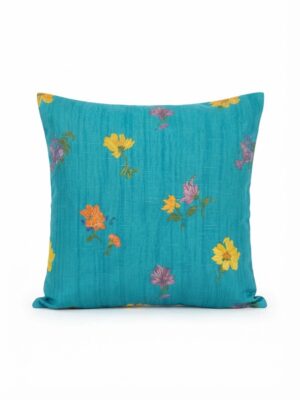 Coussin bleu turquoise avec des motifs floraux en couleurs